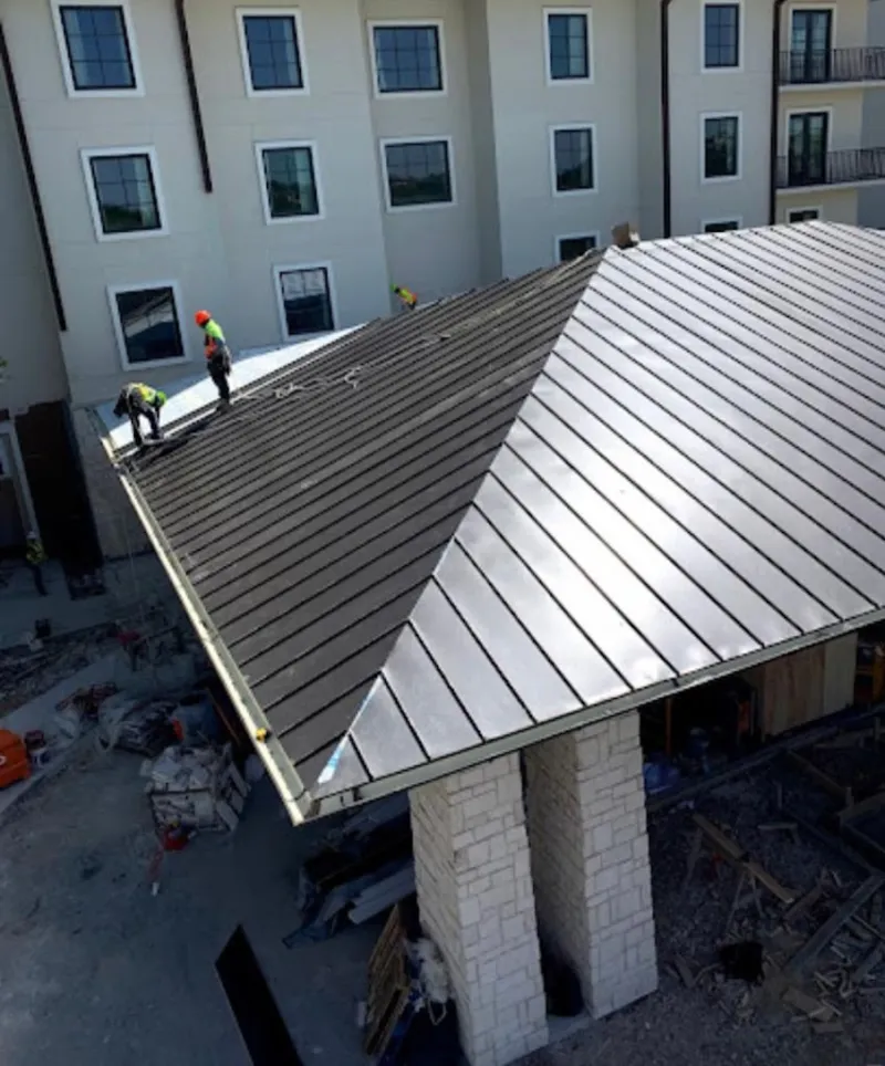 Crew installing standing seam metal roof panels on a commercial project in Fort Pierce